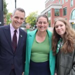 Mayor Mark Sutcliffe and Stéphanie with Heloïse Rosenfeld, a talented young student at De La Salle who sang at the event.
